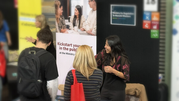 Graduate presenting to students at a university expo