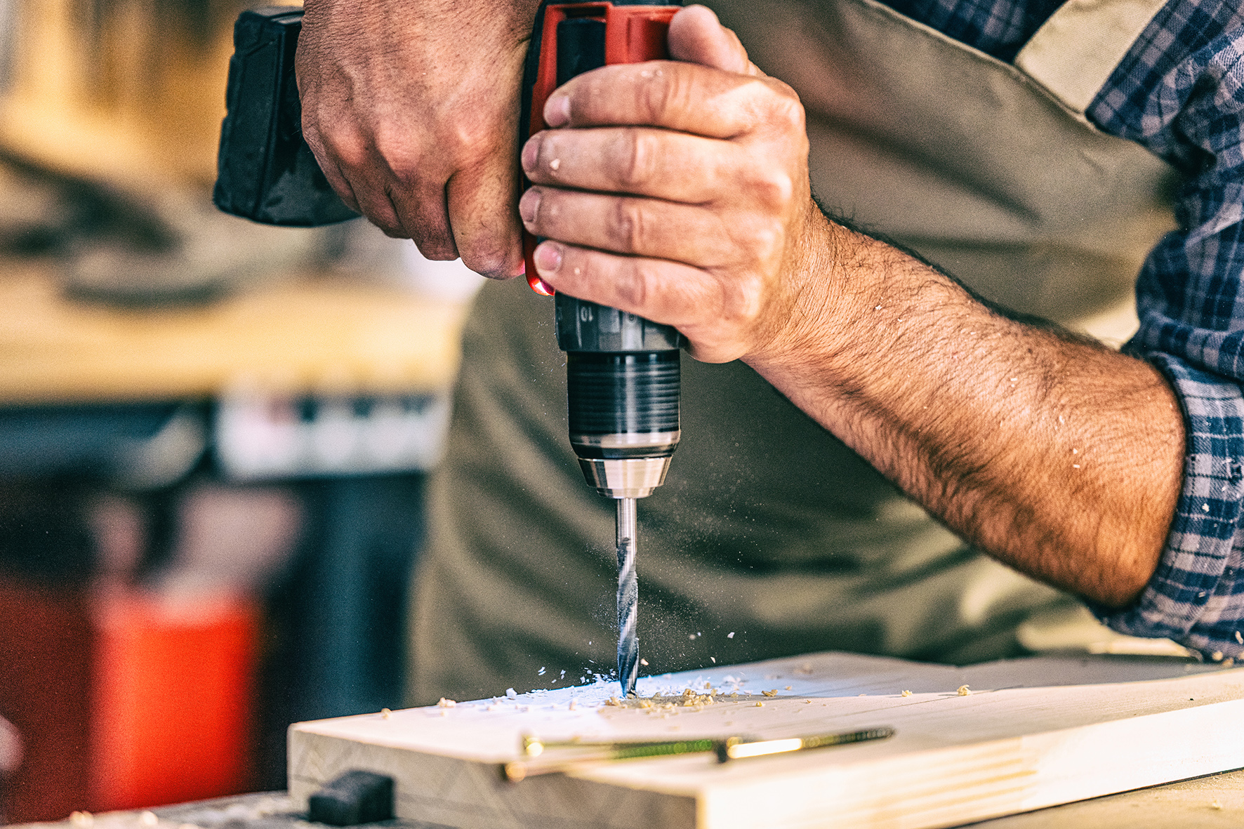 man using a drill into wood